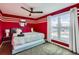 Red accent bedroom featuring a ceiling fan, striped walls, large window, and modern decor at 7074 Yates St, Westminster, CO 80030