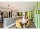 Kitchen with stainless steel appliances and bar seating open to living area with striking striped wall at 7074 Yates St, Westminster, CO 80030