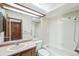 A full bathroom with a toilet, sink, vanity, tub, tiled wall, and a large mirror at 2043 E Nichols Dr, Centennial, CO 80122