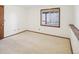 Neutral carpeted bedroom featuring a window and wood trim at 2043 E Nichols Dr, Centennial, CO 80122