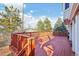 Wooden backyard deck featuring an ornate wood railing and view of trees and the fenced-in backyard at 2043 E Nichols Dr, Centennial, CO 80122