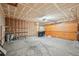 Unfinished two car garage with large work area, shelving, and garage door at 2043 E Nichols Dr, Centennial, CO 80122