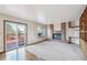 Bright living room featuring brick fireplace, carpet, and slider door to an outdoor deck at 2043 E Nichols Dr, Centennial, CO 80122