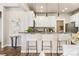 Modern kitchen with white cabinets, breakfast bar, and granite countertops at 9769 W Stanford Ave, Denver, CO 80123