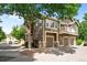 Inviting exterior showcasing a multi-level home with a balcony and three-car garage, enhanced by mature trees at 19663 E Mann Creek Dr # D, Parker, CO 80134