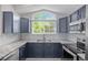 Modern kitchen showcasing sleek countertops, navy cabinetry, stainless steel appliances, and stylish tile backsplash at 19663 E Mann Creek Dr # D, Parker, CO 80134