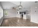 Bright, open-concept living room with hardwood floors, ceiling fan, and an adjacent kitchen area at 19663 E Mann Creek Dr # D, Parker, CO 80134