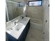 Modern bathroom with a double sink vanity, bathtub and large mirror at 1256 Yates St, Denver, CO 80204