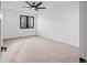 Spacious bedroom features neutral carpet, ceiling fan and window with black trim at 1256 Yates St, Denver, CO 80204