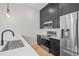 Modern kitchen featuring sleek black cabinets, stainless steel appliances and hardwood flooring at 1256 Yates St, Denver, CO 80204