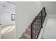 Staircase with carpeted steps, black metal railings, and white walls at 1256 Yates St, Denver, CO 80204