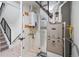 Well-lit utility room with new appliances, a water heater, and access to the stairs at 1256 Yates St, Denver, CO 80204