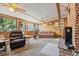 Bright sun room features wood paneling, brick fireplace, and ample natural light at 7750 W 5Th Ave, Lakewood, CO 80226