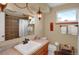 Bathroom featuring a sink, mirror, vanity lighting, and a tiled shower/tub combo at 3241 S Krameria St, Denver, CO 80222