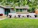 Charming home exterior with beautifully landscaped front yard and blooming flower pots at 3241 S Krameria St, Denver, CO 80222