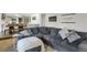 Spacious living room features stylish gray sectional sofa, adjacent to the kitchen with modern furnishings at 3241 S Krameria St, Denver, CO 80222