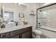 Bright bathroom with marble counters, dark wood vanity and a glass door shower at 5423 S Prince St # B, Littleton, CO 80120