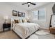 Bright bedroom featuring neutral decor, a ceiling fan, and a large window at 5423 S Prince St # B, Littleton, CO 80120
