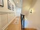 Hallway with decorative wainscotting, hardwood floors, and modern lighting at 5423 S Prince St # B, Littleton, CO 80120
