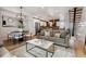 Open-concept living room with modern decor, hardwood floors, and a view of the adjacent dining area and kitchen at 5423 S Prince St # B, Littleton, CO 80120