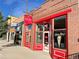 Charming brick storefront with red trim, featuring an ice cream shop and a barbershop at 5423 S Prince St # B, Littleton, CO 80120