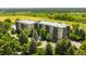 A beautiful exterior view showcasing the building's modern architecture, mature trees, and well-kept landscaping at 14300 E Marina Dr # 306, Aurora, CO 80014