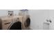 A laundry room featuring a modern, front-load washer and dryer set with ample counter space at 14300 E Marina Dr # 306, Aurora, CO 80014