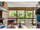 Sunroom with a view of trees, a red metal table and chairs, and plants at 14300 E Marina Dr # 306, Aurora, CO 80014