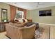 Cozy living room with brown couches, ceiling fan, and large window, providing ample natural light at 4820 W 125Th Ave, Broomfield, CO 80020