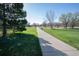 Scenic concrete walking path surrounded by lush greenery and mature trees in the community at 4820 W 125Th Ave, Broomfield, CO 80020
