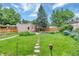 Lush backyard with a stone pathway, mature trees, and well-maintained landscaping at 4045 E 18Th Ave, Denver, CO 80220