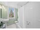 Bright bathroom featuring a white tiled shower and tub combination, with natural light and views at 4045 E 18Th Ave, Denver, CO 80220