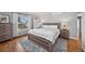 Bright bedroom featuring wood flooring, a large window, and light gray walls complemented by neutral-toned furniture at 4045 E 18Th Ave, Denver, CO 80220