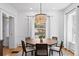 Elegant dining room with chandelier, wood table and views of the yard through bright windows at 4045 E 18Th Ave, Denver, CO 80220