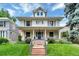 Charming two-story home featuring a covered porch, mature landscaping, and a welcoming entrance at 4045 E 18Th Ave, Denver, CO 80220