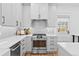 Bright kitchen with stainless steel oven, gray cabinetry, white countertops, and subway tile backsplash at 4045 E 18Th Ave, Denver, CO 80220