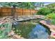 Backyard pond with rock feature, trees and lush greenery at 4045 E 18Th Ave, Denver, CO 80220