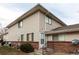 Tan two-story condo building with brick base and landscaping at 9255 E Lehigh Ave # 211, Denver, CO 80237