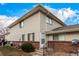 Tan two-story building with brick and siding, showing a private entrance and small yard at 9255 E Lehigh Ave # 211, Denver, CO 80237