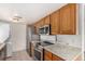 Galley kitchen with wood cabinets and stainless steel appliances at 9255 E Lehigh Ave # 211, Denver, CO 80237