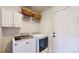 Well-equipped laundry room has a washer, dryer, storage cabinets, and door to exterior at 8910 Rutgers St, Westminster, CO 80031