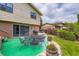 The patio has a dining table, and a green painted surface with a view of the lush backyard at 3724 S Poplar St, Denver, CO 80237