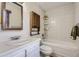 Bright bathroom featuring a white vanity, matching toilet, and a bathtub with a white tiled wall at 3724 S Poplar St, Denver, CO 80237