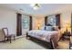 Bedroom with a large bed, two windows with blinds, a chair, and two bedside tables at 3724 S Poplar St, Denver, CO 80237