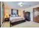 Bedroom with a queen bed, bedside lamps, a window and a wooden armoire at 3724 S Poplar St, Denver, CO 80237