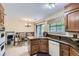 Functional kitchen with wooden cabinets, granite countertops, modern appliances, and a breakfast nook with backyard views at 3724 S Poplar St, Denver, CO 80237