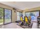 Bright sunroom featuring tile floors, glass windows, and a yellow chair set, perfect for relaxing indoors at 3724 S Poplar St, Denver, CO 80237