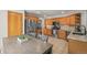 Spacious kitchen featuring wood cabinets, granite countertops, stainless steel appliances, and an adjacent dining area at 2602 E 145Th Ave, Thornton, CO 80602
