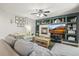 Cozy living room showcasing a fireplace, built-in shelving, a ceiling fan, and comfortable seating arrangement at 2602 E 145Th Ave, Thornton, CO 80602