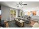 Comfortable living room area with large windows, a sectional sofa, and a view of the adjacent kitchen space at 2602 E 145Th Ave, Thornton, CO 80602